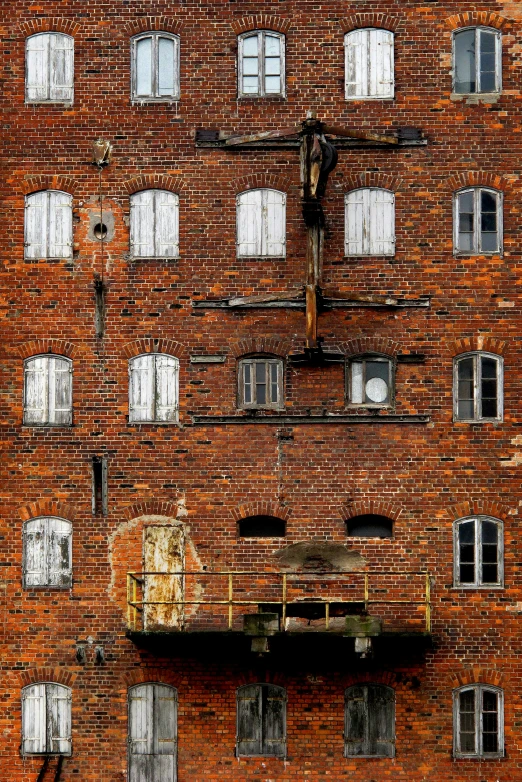 an old brick building with windows and a metal beam sticking out