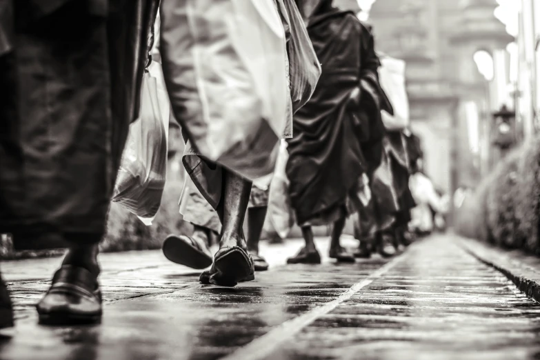 this is the back view of many people with long hair walking down a wet street