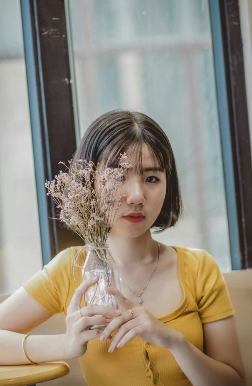 a woman holding a vase full of flowers at a table