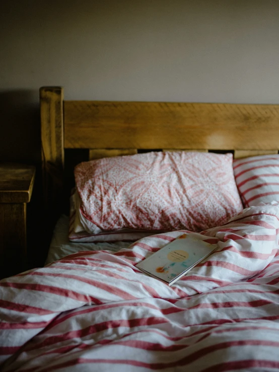 a small bed with red and white striped sheets