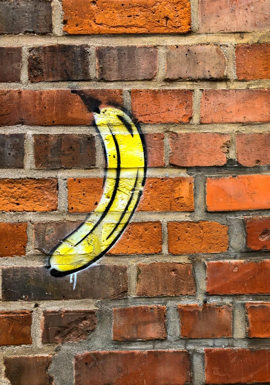 a large banana on a brick wall