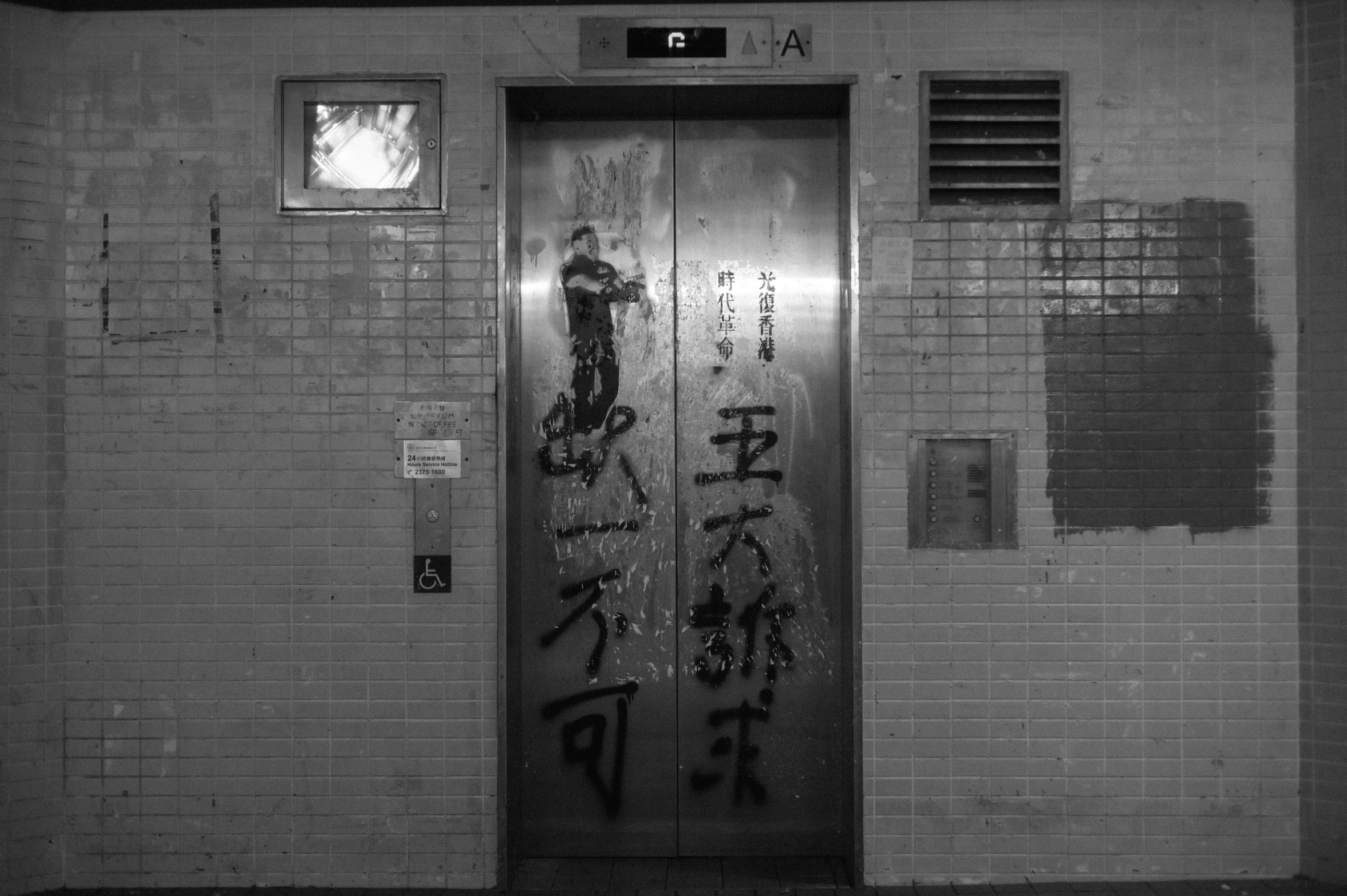 an oriental type metal door next to a brick wall