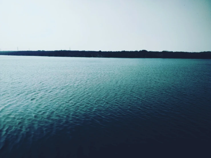 the calm ocean is shown on a clear day