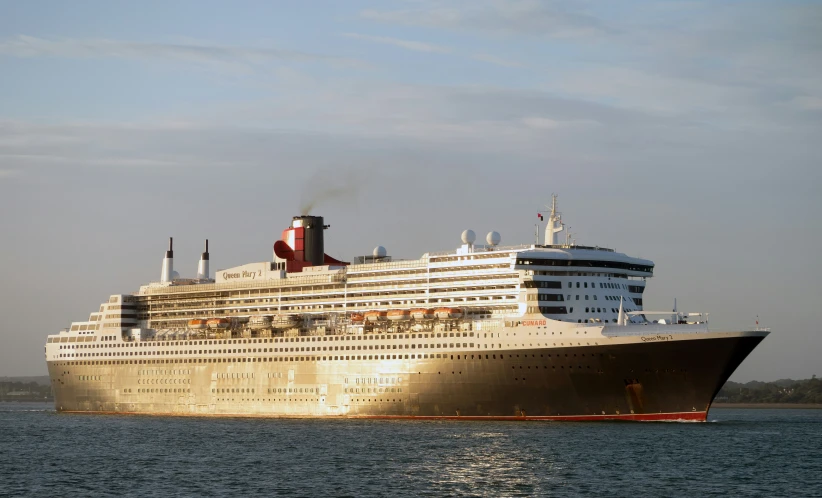 a large cruise ship in the water with its smoke stack sticking out