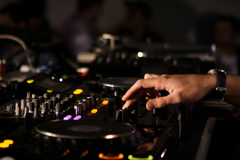 a person using a record player in front of a mixer