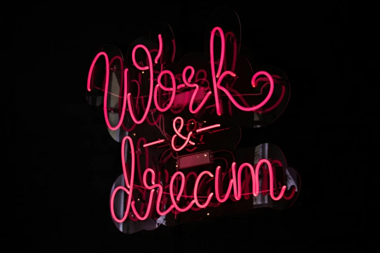 a neon sign that says work and dream