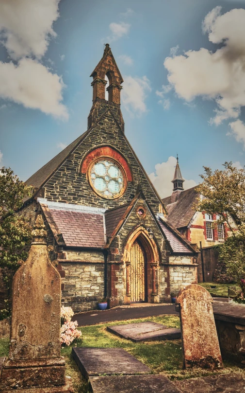 an old church with a small graveyard on the ground and a stone clock