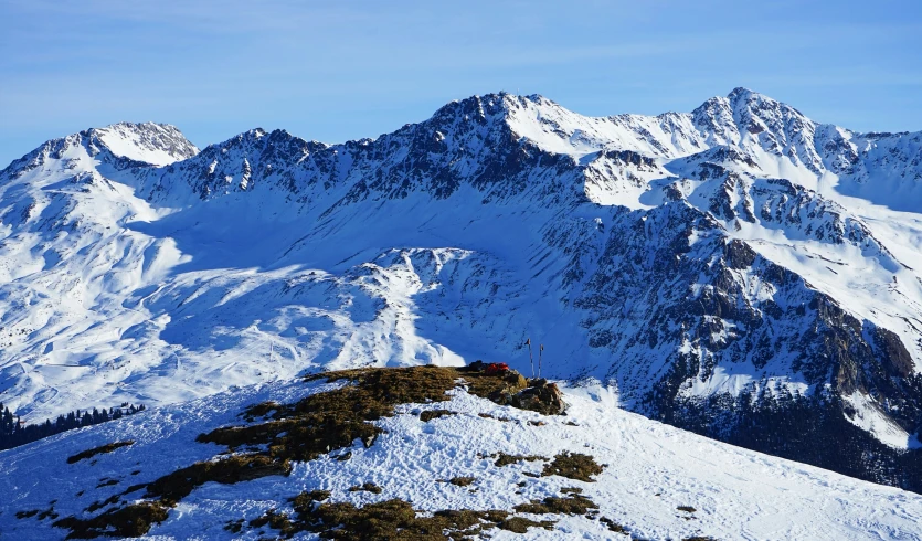 the mountains are covered in snow with the sky