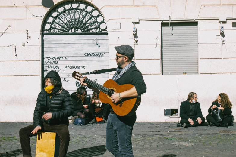 a man wearing a hat while playing the guitar