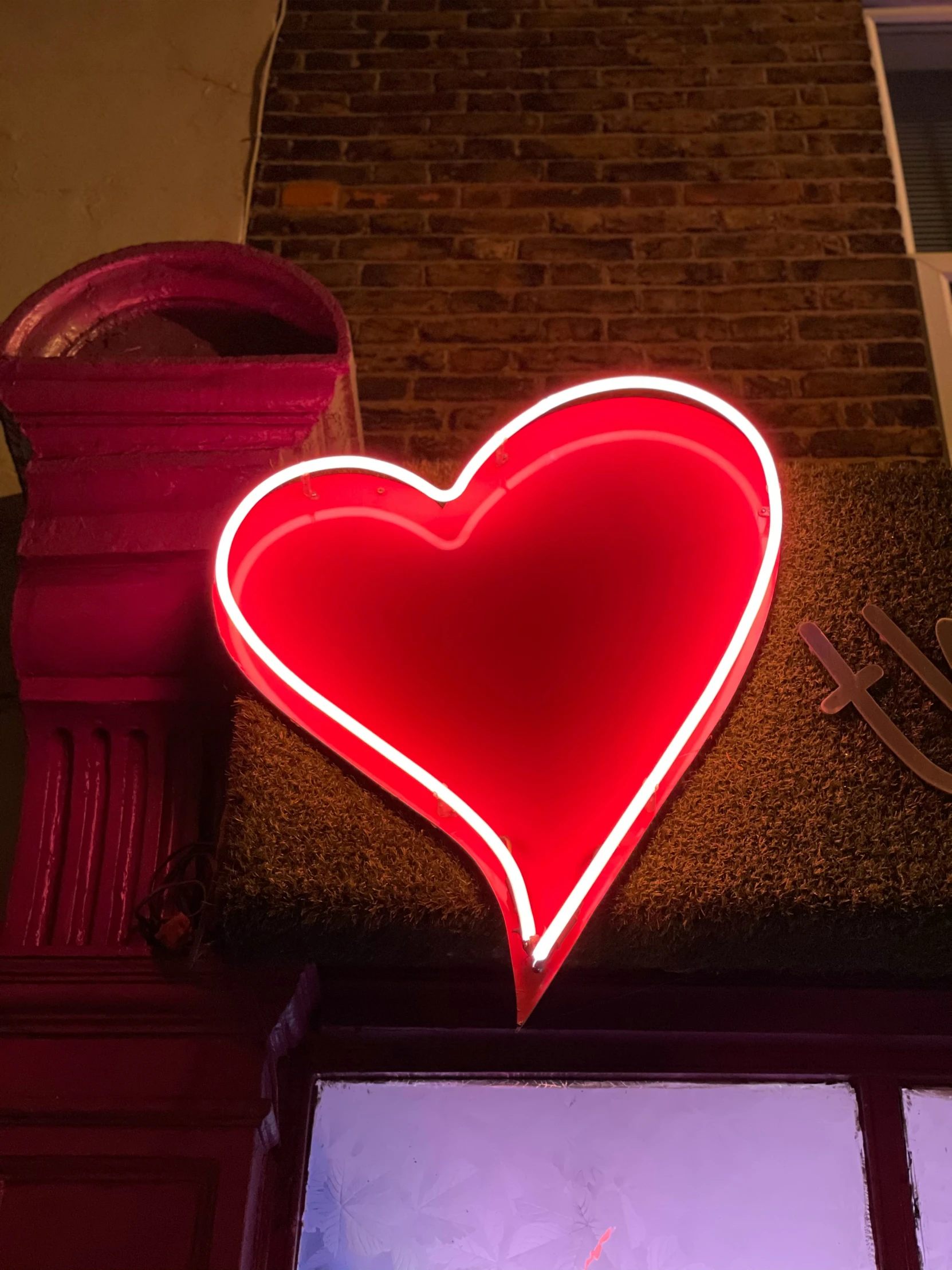 a red heart shaped neon sign is lit up