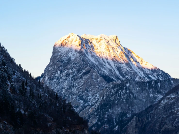 the snow capped mountains are rising up in a blue sky