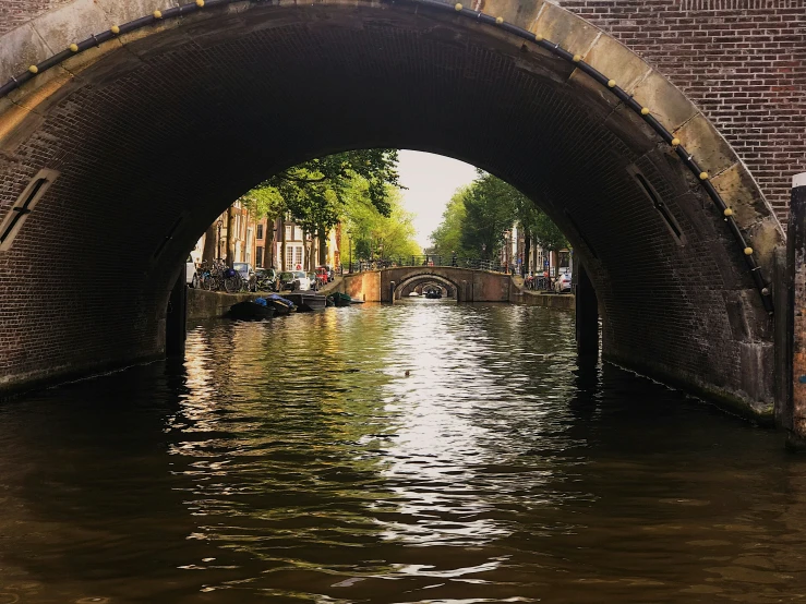 a small canal running under an overpass in a city