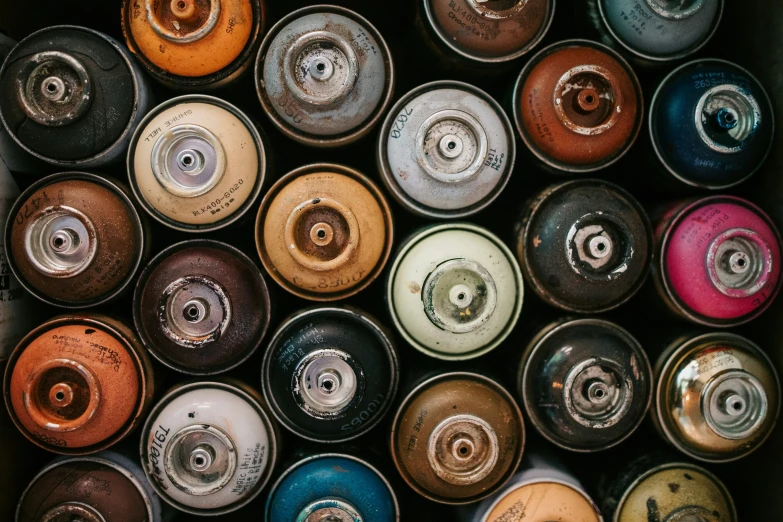 several cans are stacked side by side and have different colors of paint in them
