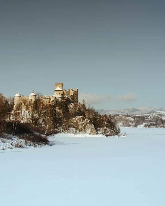 a castle is standing on the edge of a lake