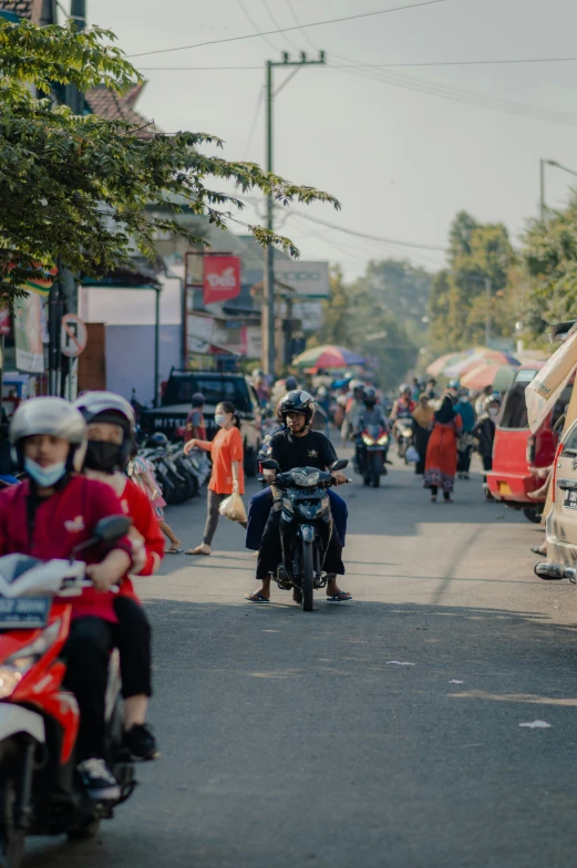 some motorcyclists riding down a crowded city street