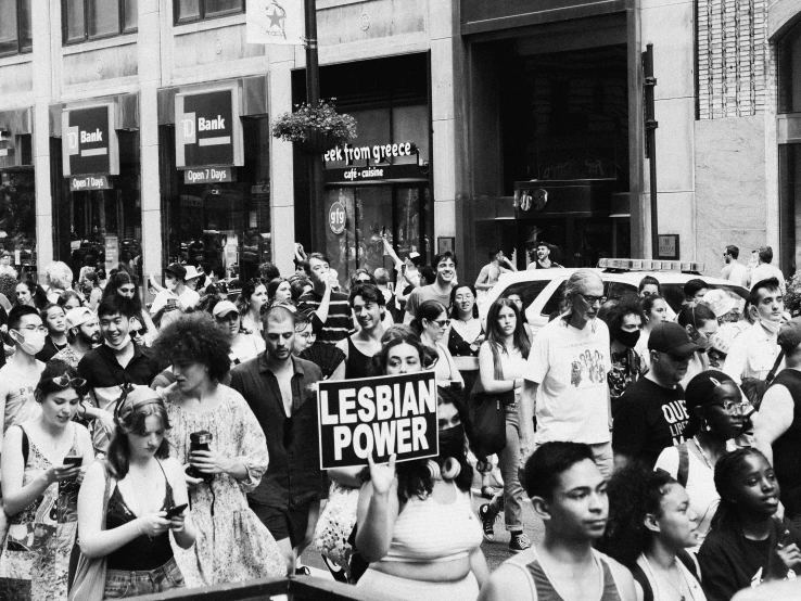 a crowd of people with signs in front of buildings