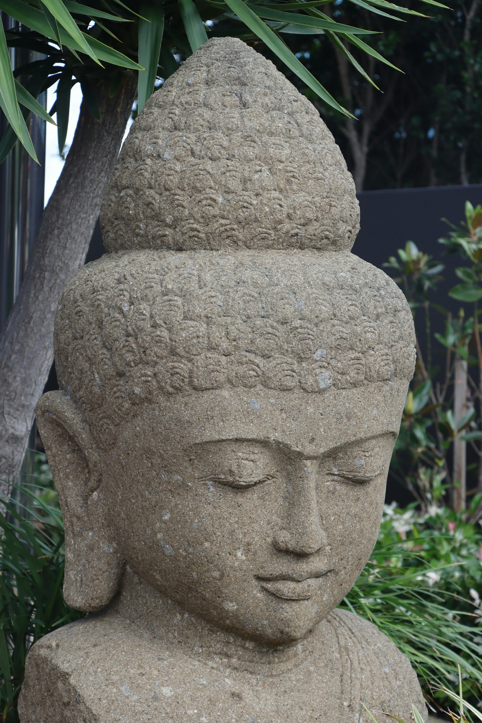 a large stone statue is sitting in a garden