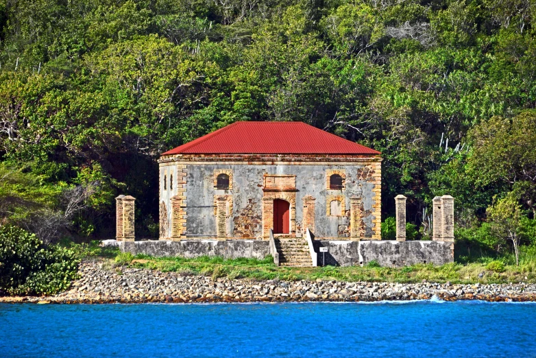 a house sitting on a cliff next to a lake