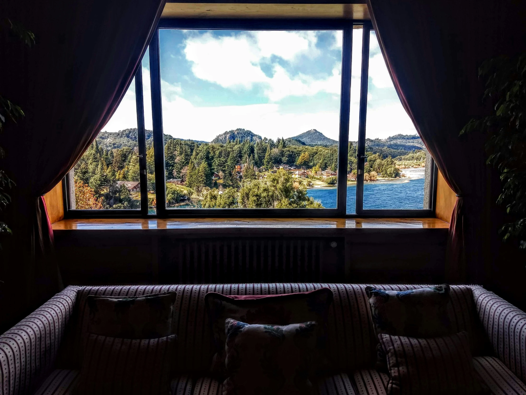 the view out the window of a room overlooking a lake