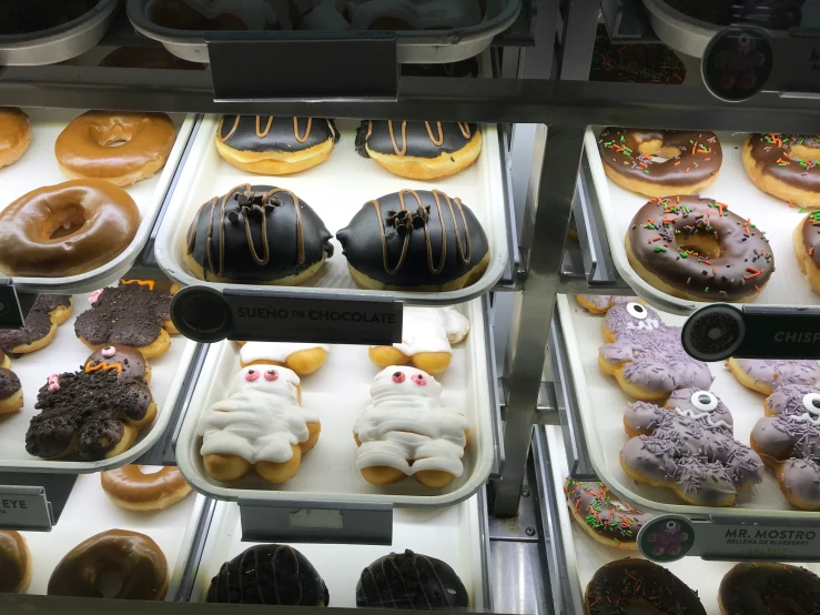 a display case of donuts with various designs