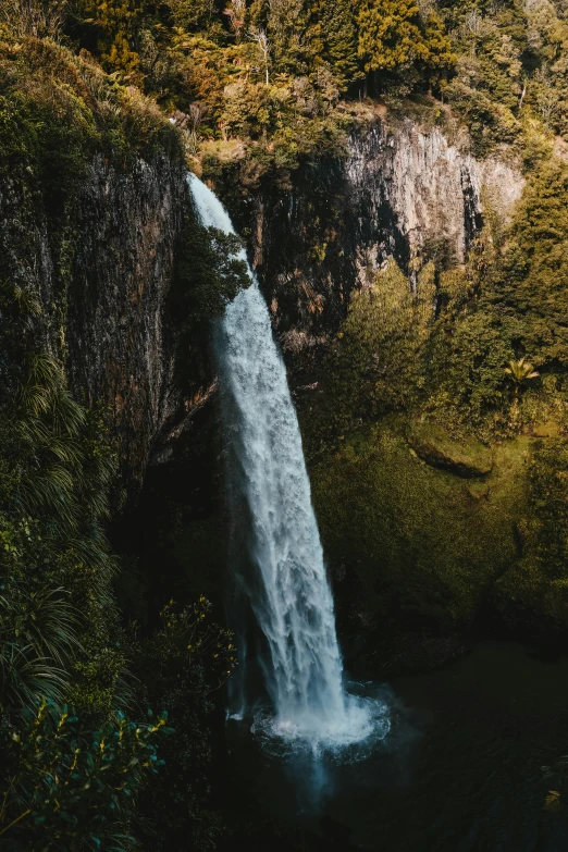 water is gushing from the side of a rocky mountain stream