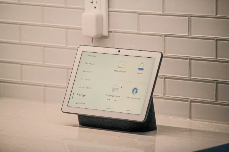 an ipad stand on a counter with a white wall in the background