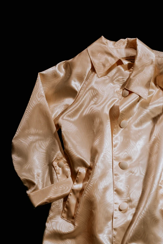 an antique jacket laying on a black background