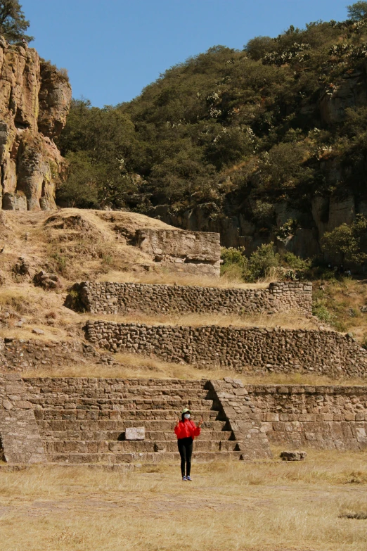 a man standing near many very tall stone structures