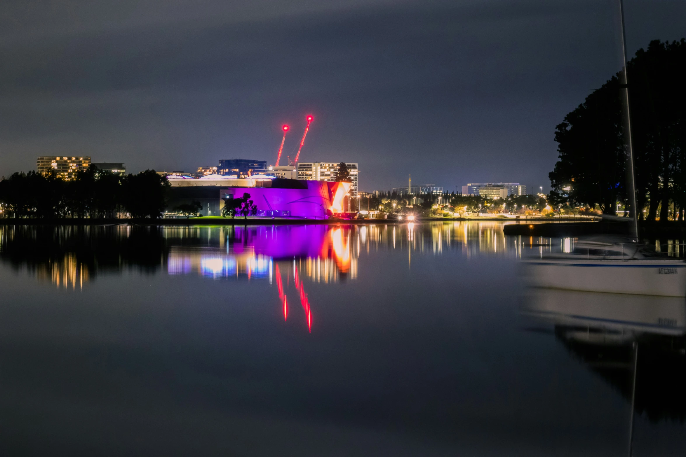 a boat on the water and lights in the background