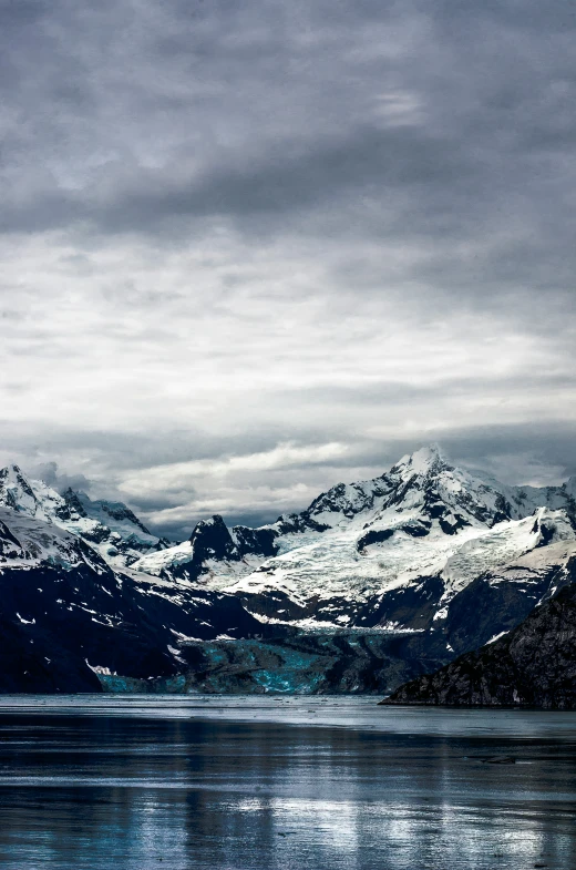 snow covered mountains and ice floes surround the water