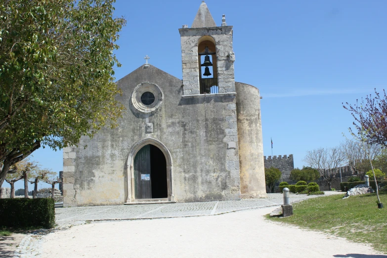 an old church with tall bell tower sitting next to a small tree