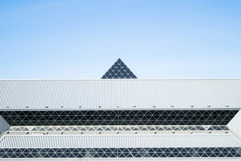 the triangular shaped building is near the blue sky