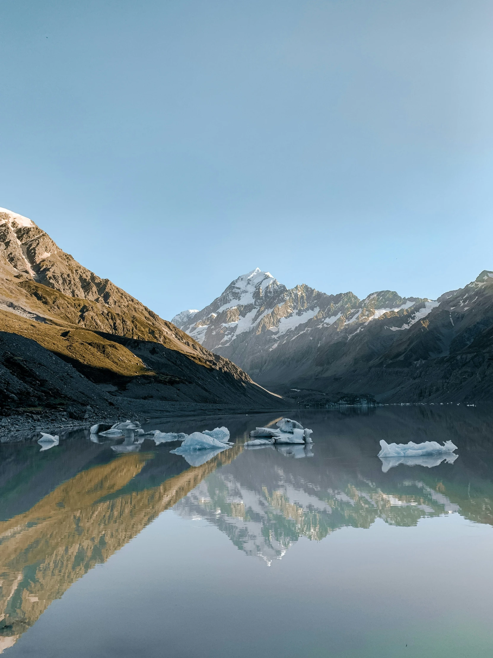 a lake with mountains in the background near snow