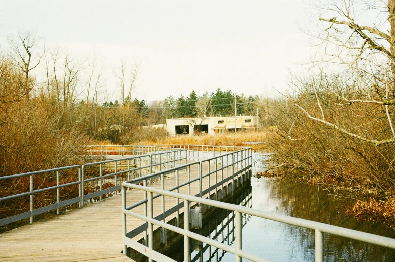 a bridge is crossing over some water on a boardwalk