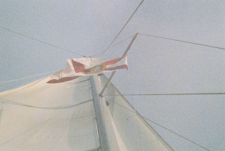 the front end of a sail boat sailing under blue skies