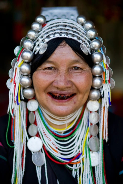 a woman with beaded headgear smiles and looks at the camera