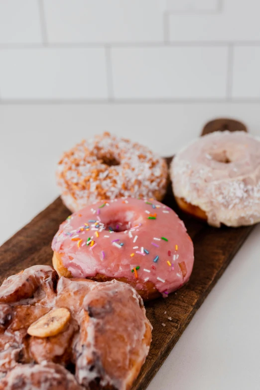 a wood platter filled with different kinds of donuts