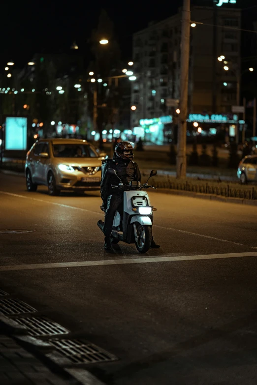 motorcyclist riding in middle of a city street at night