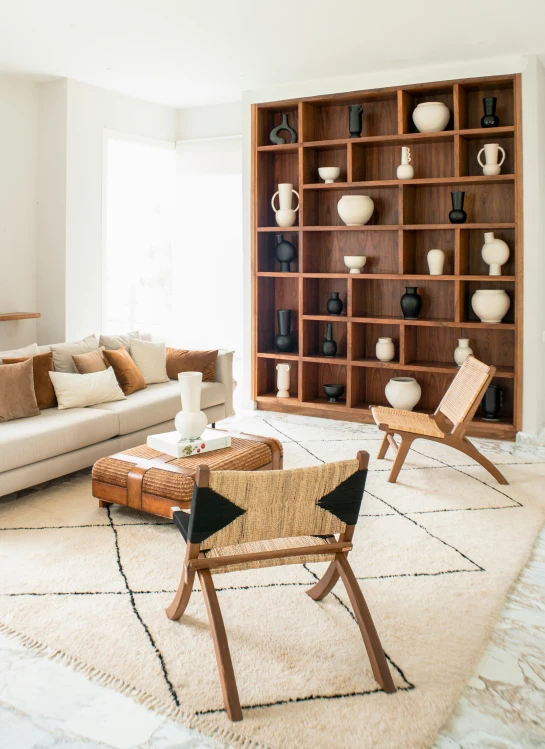 a living room with chairs, furniture and shelves