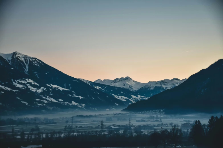 a mountain scene with low clouds and trees