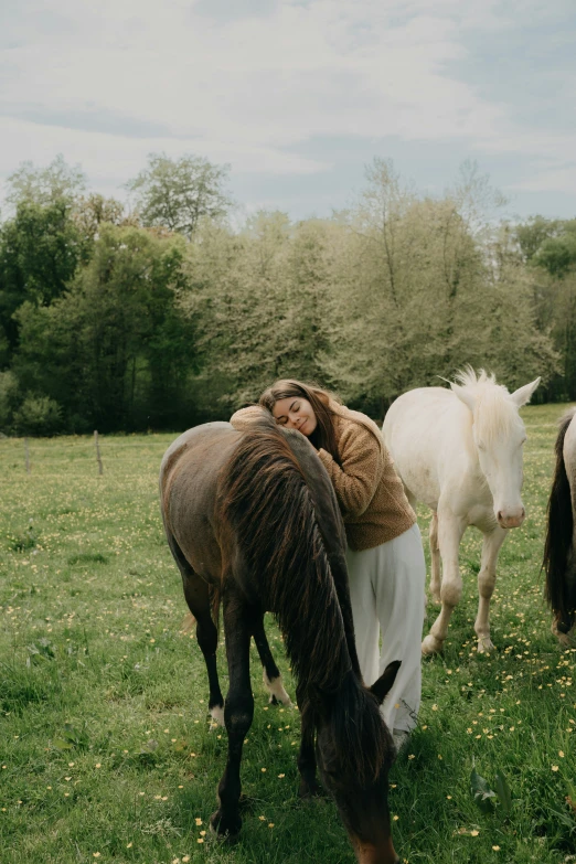 a woman sitting on top of a horse next to two horses