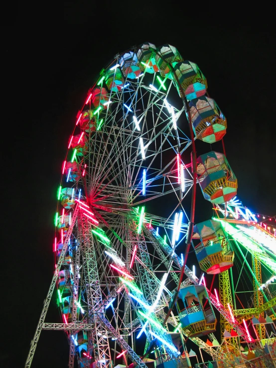 a brightly lit ferris wheel in the night