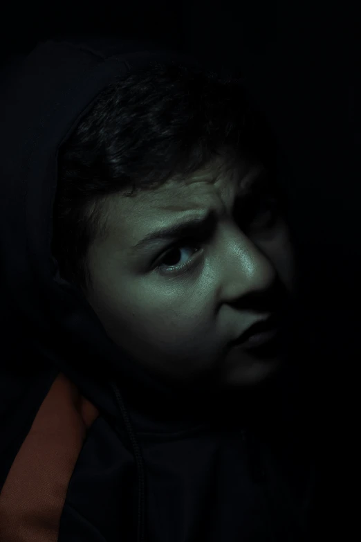 a child in the dark with a hoodie on