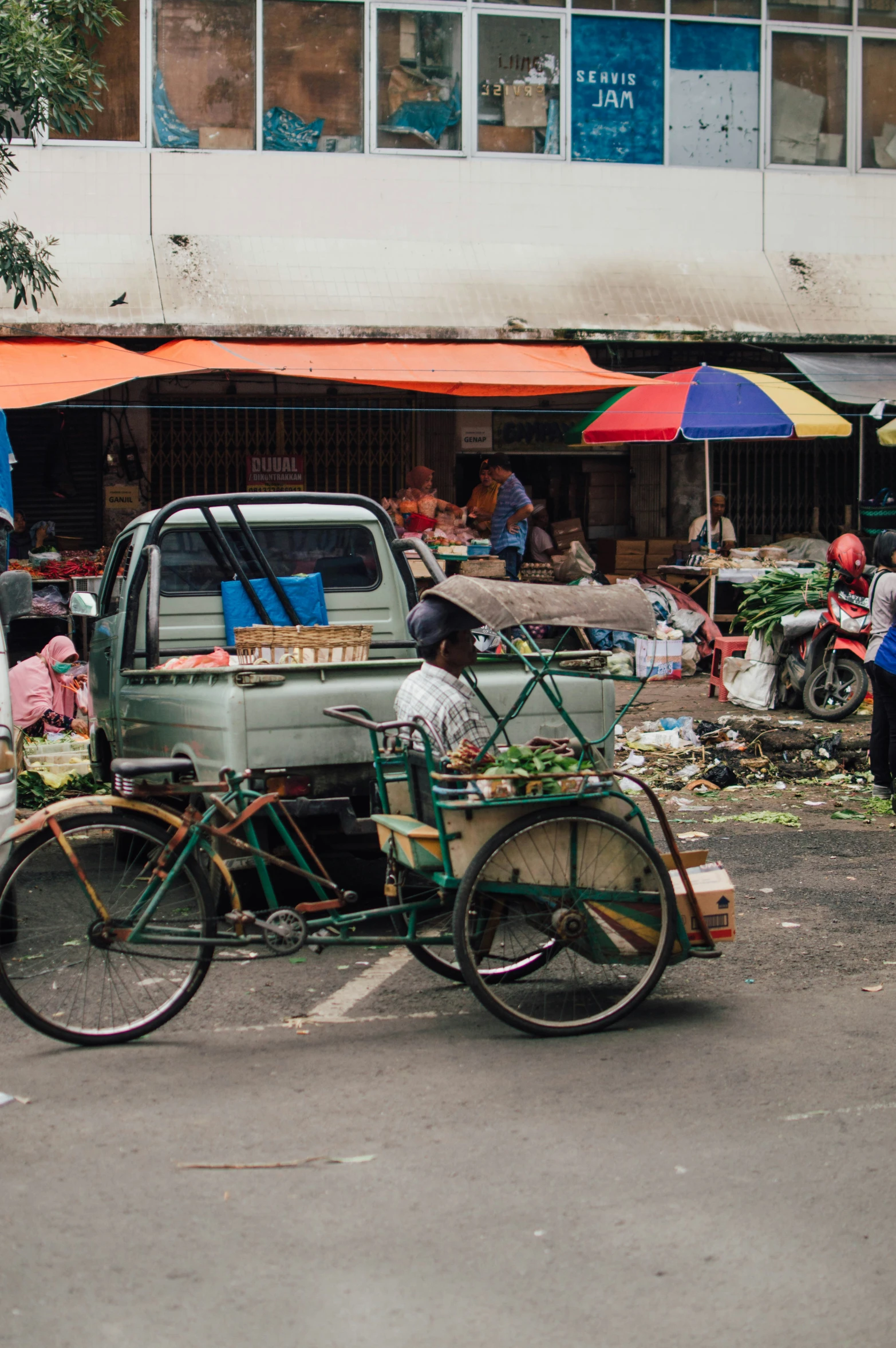 a green car and a green bicycle on a street