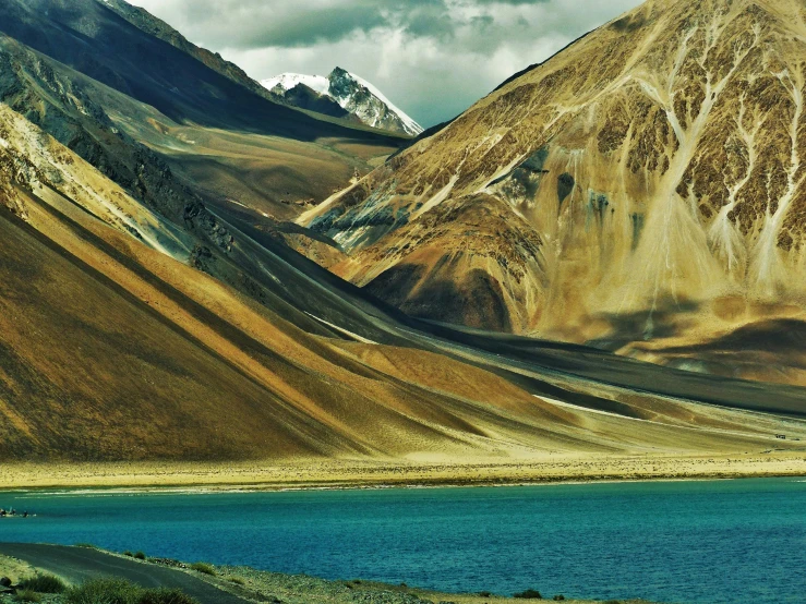 a large mountain range next to water and clouds