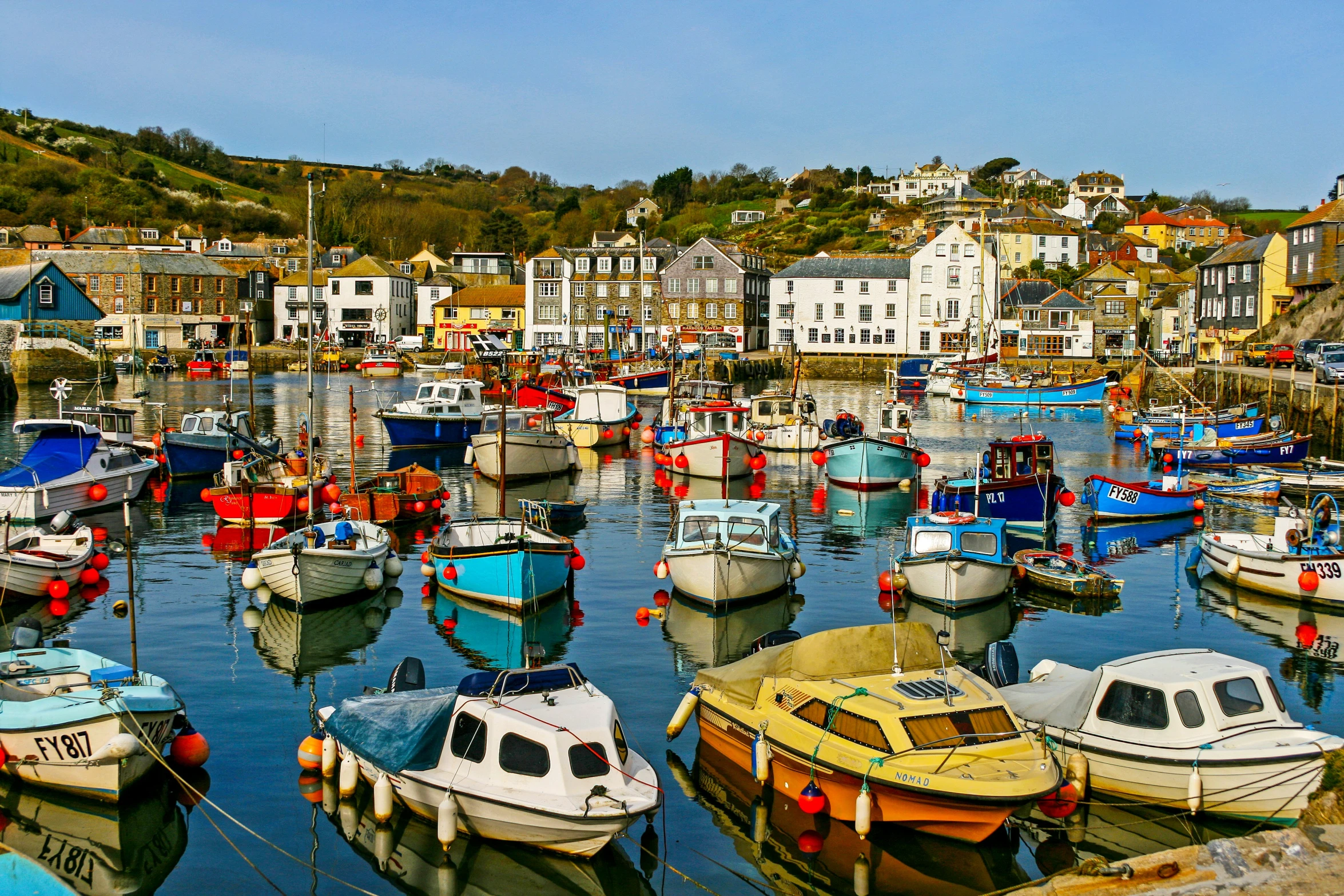 colorful boats float in the still water on the bay