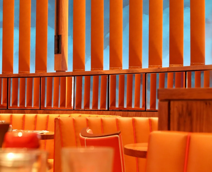 a restaurant with tables and orange chairs in the middle