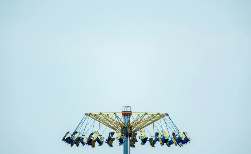 people are riding the carousel with the sky in the background