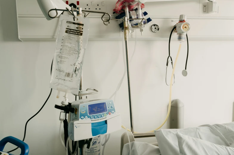 an iv stand in the middle of a hospital bed with medical equipment hanging above it