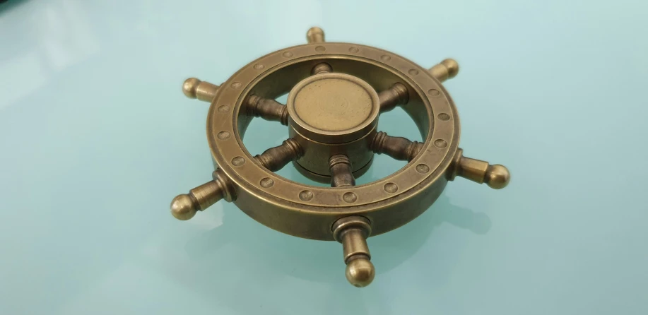 a ss ship steering wheel on a light blue surface